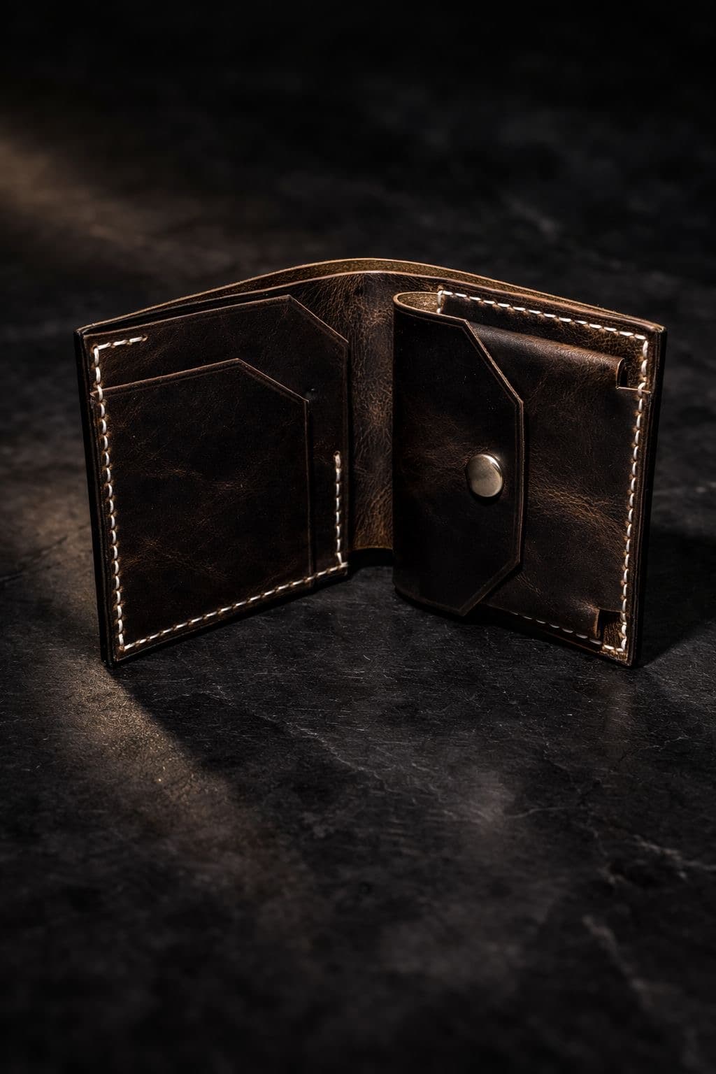 Kankia dark brown bifold wallet open, showing four card slots and a coin pocket with brass snap