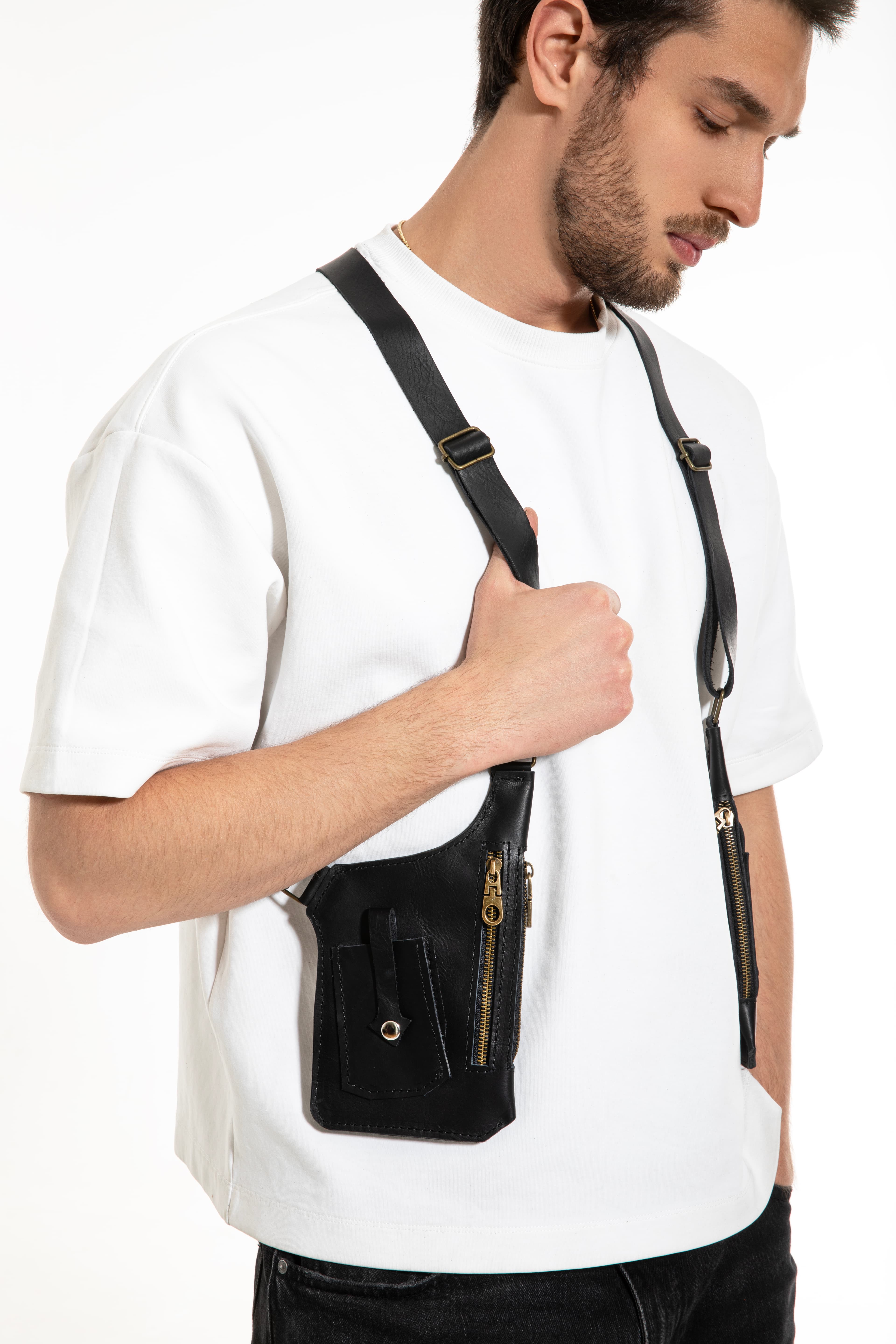 Model wearing a Kankia black leather single-strap crossbody bag with gold zipper, white background