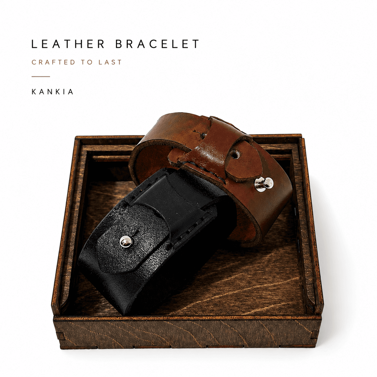 Kankia leather bracelet product shot — tan and black cuff bracelets displayed in a dark wooden box